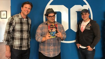 Josh Gad poses with DC Films presidents and a Penguin comic